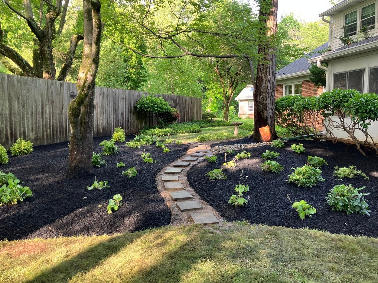 Beautiful landscaped garden with stone path and shade trees by First Class Lawncare, LLC in Wilmington, DE