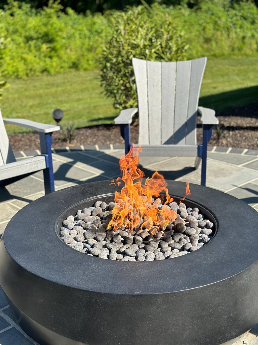 Close-up of firepit fire and patio chairs on patio hardscaping and landscaping by First Class Lawn Care in Wilmington, DE