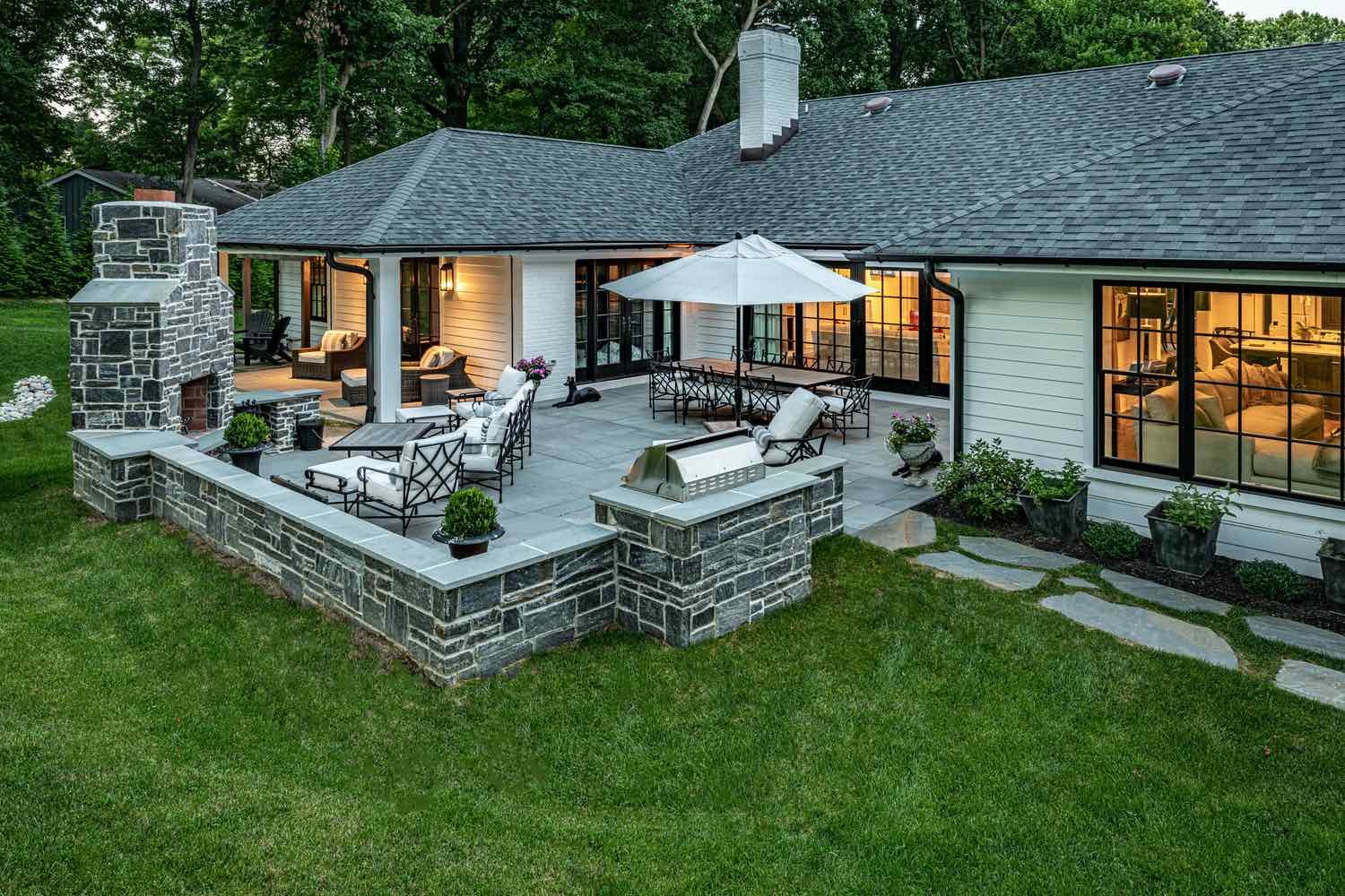 Hardscaped Back Yard With Fireplace and Seating By First Class Lawn Care