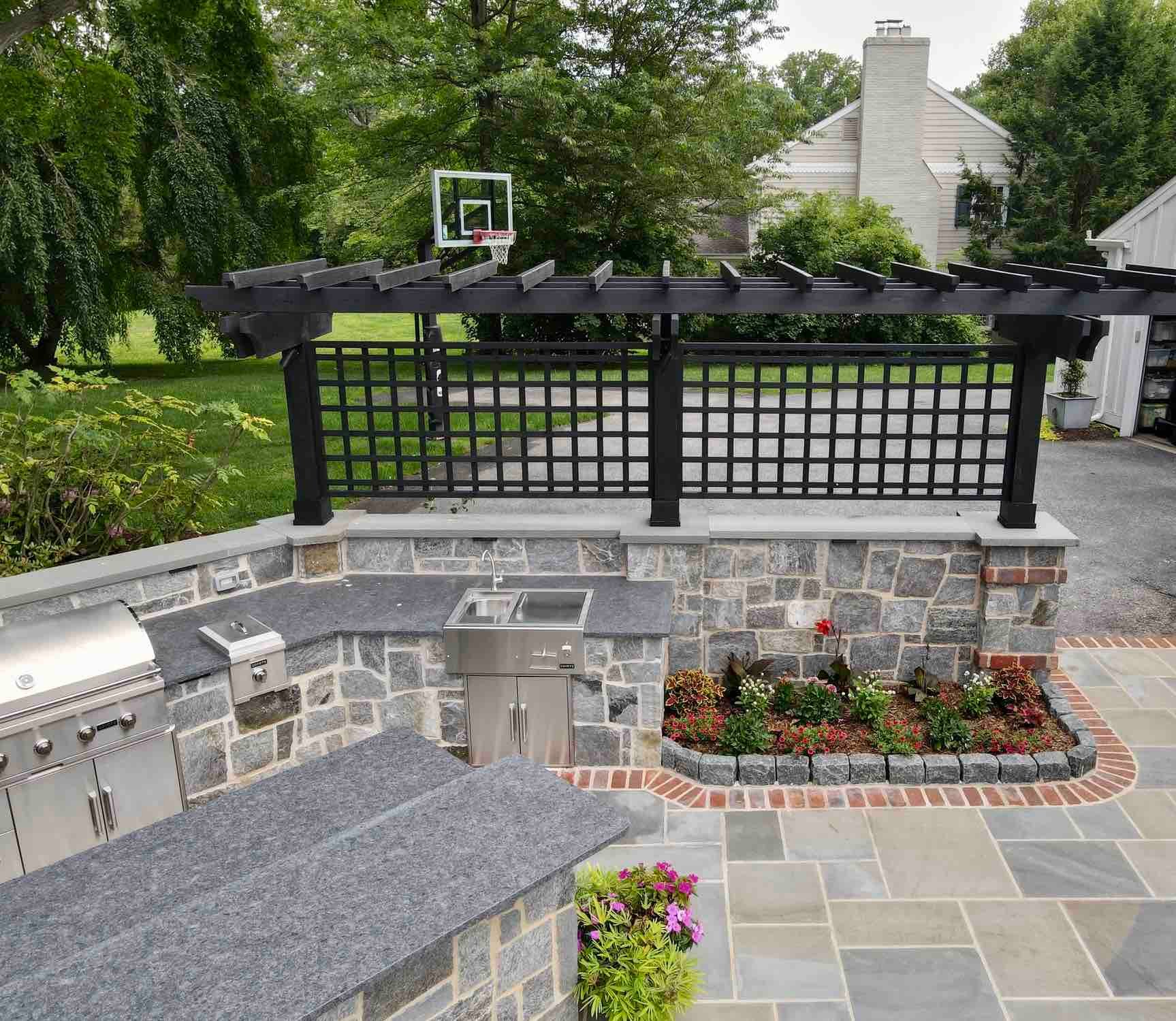 Outdoor Kitchen With View of Garage by First Class Lawn Care