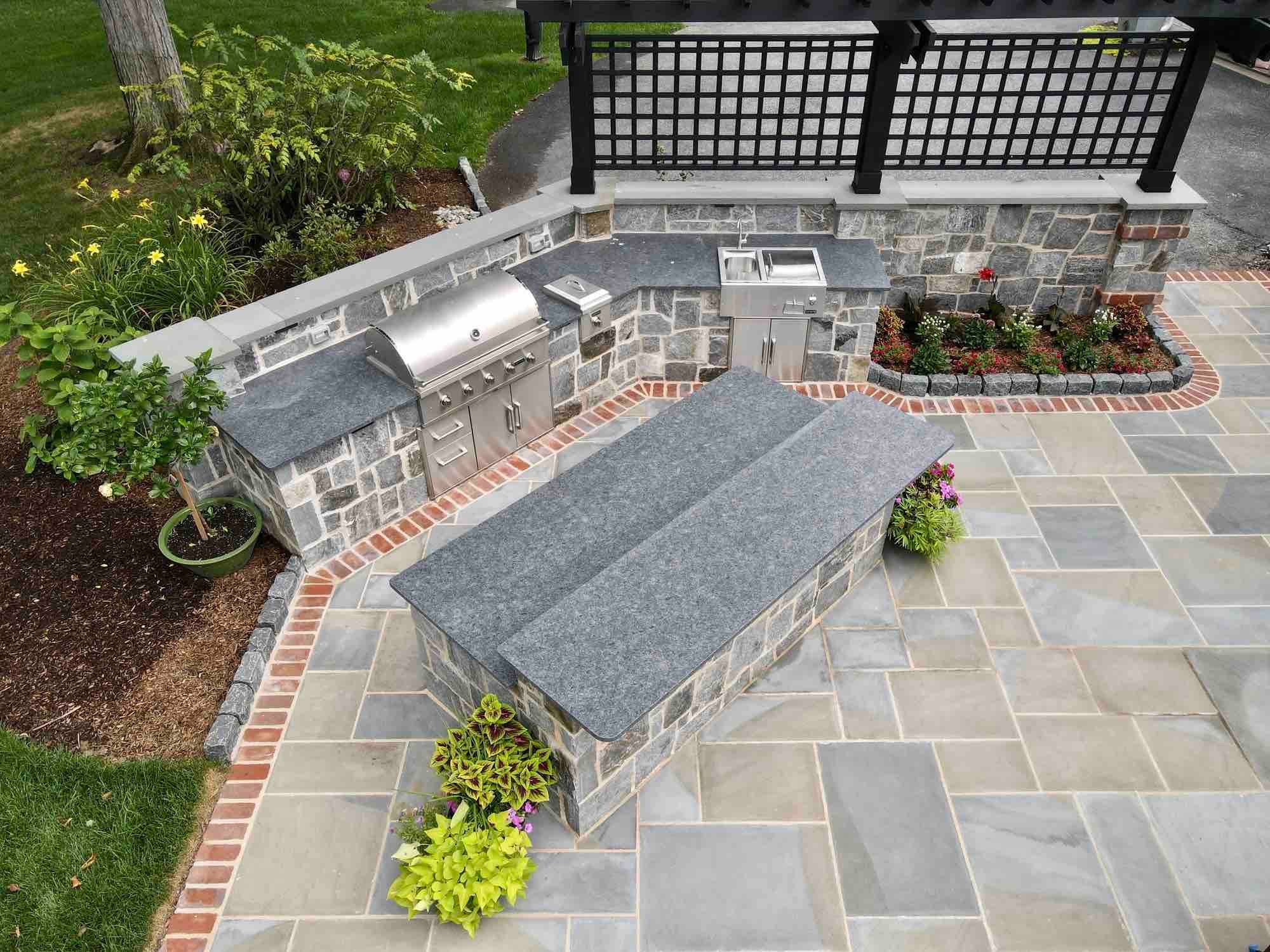 View Of Outdoor Kitchen and Patio From Second Story Inside Home by First Class Lawn Care