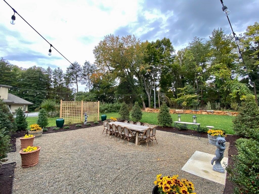 Custom Landscaped Back Yard with Lighting and Outdoor Table by First Class Lawn Care