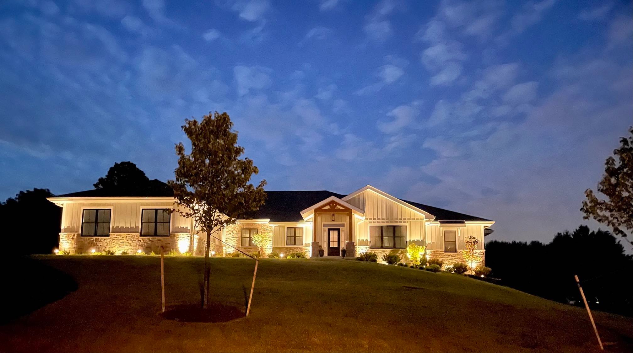 Front Of House View With Custom Lighting And Landscaping by First Class Lawn Care